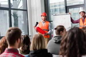 Workplace fire safety statistics showing workers in an industrial facility with fire prevention equipment